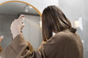 young woman applying anti dandruff product